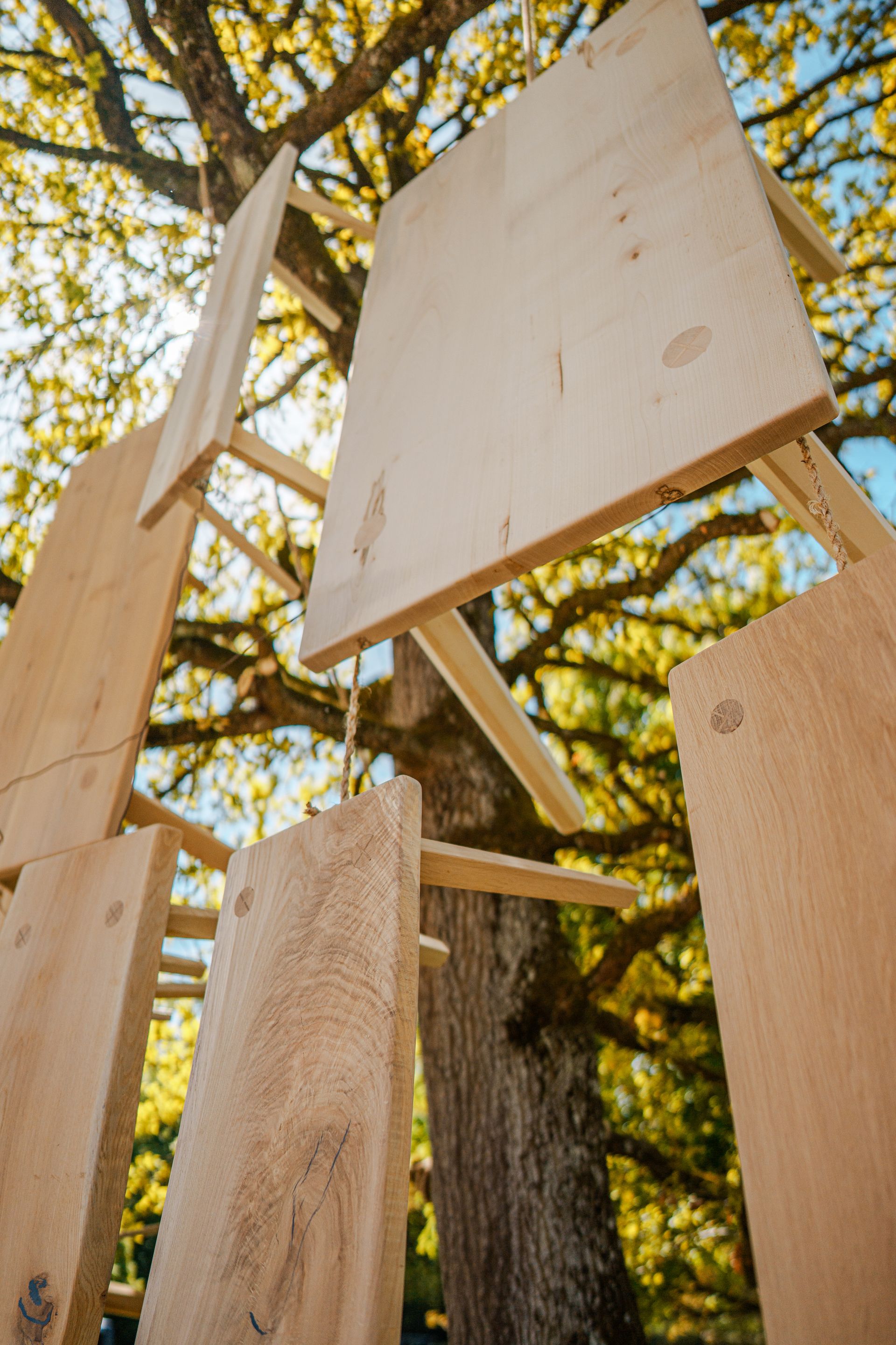 Xaverl — Tische und Hocker, an einem Baum aufgehängt